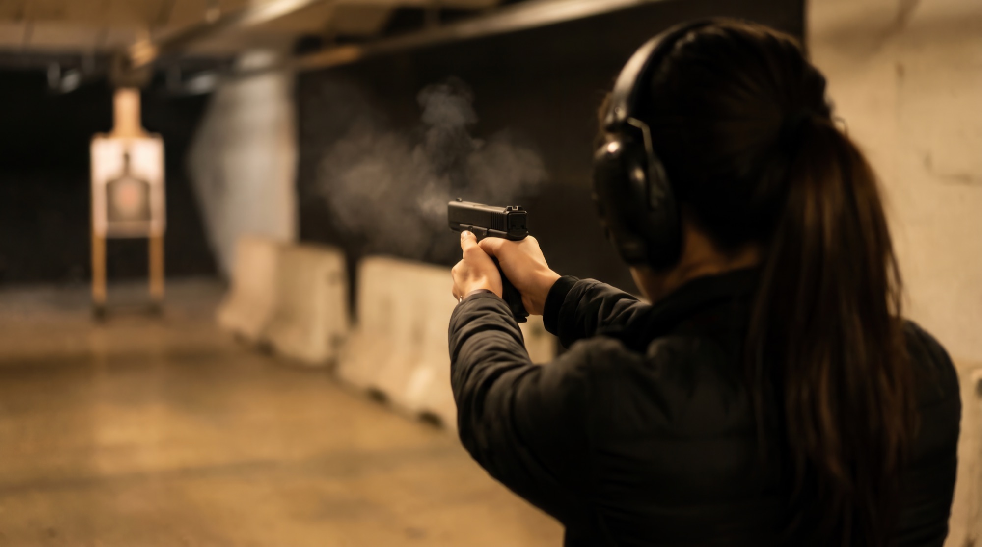 A shooter on an indoor range lane, target downrange