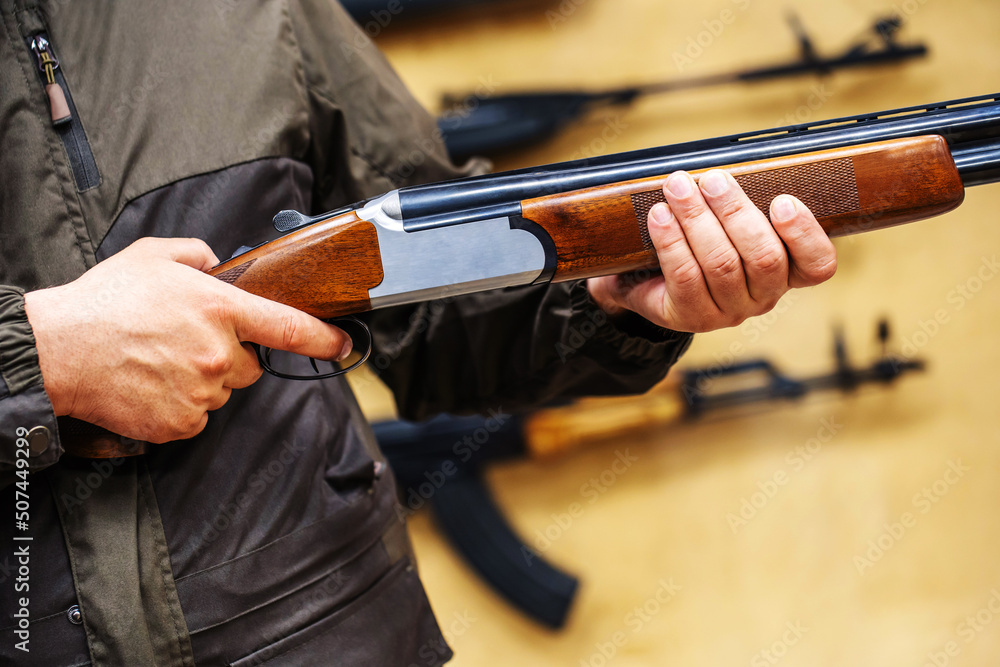 A customer’s hands on an over-and-under shotgun at the counter